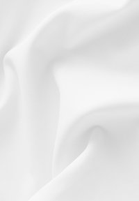 Tessuto bianco con una texture liscia, caratterizzato da pieghe morbide e un drappeggio sottile. Il materiale appare leggero e lucido.