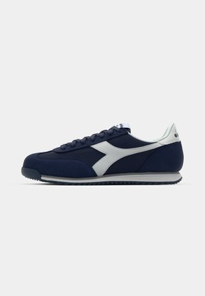 Zapatillas deportivas en navy con parte superior de malla y gamuza, acentos blancos, puntera redonda, suela plana y dibujo texturizado para tracción.