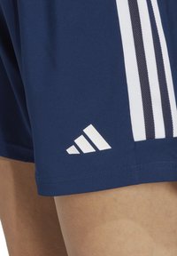 Dunkelblaue Sportshorts mit weißen Adidas-Streifen, ausgestattet mit einem strukturierten weißen Logo am Saum und glattem Stoff.