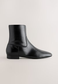 Schwarzer Lederstiefelette mit niedrigem Absatz und spitzer Schuhspitze, seitlich auf neutralem Hintergrund abgebildet.