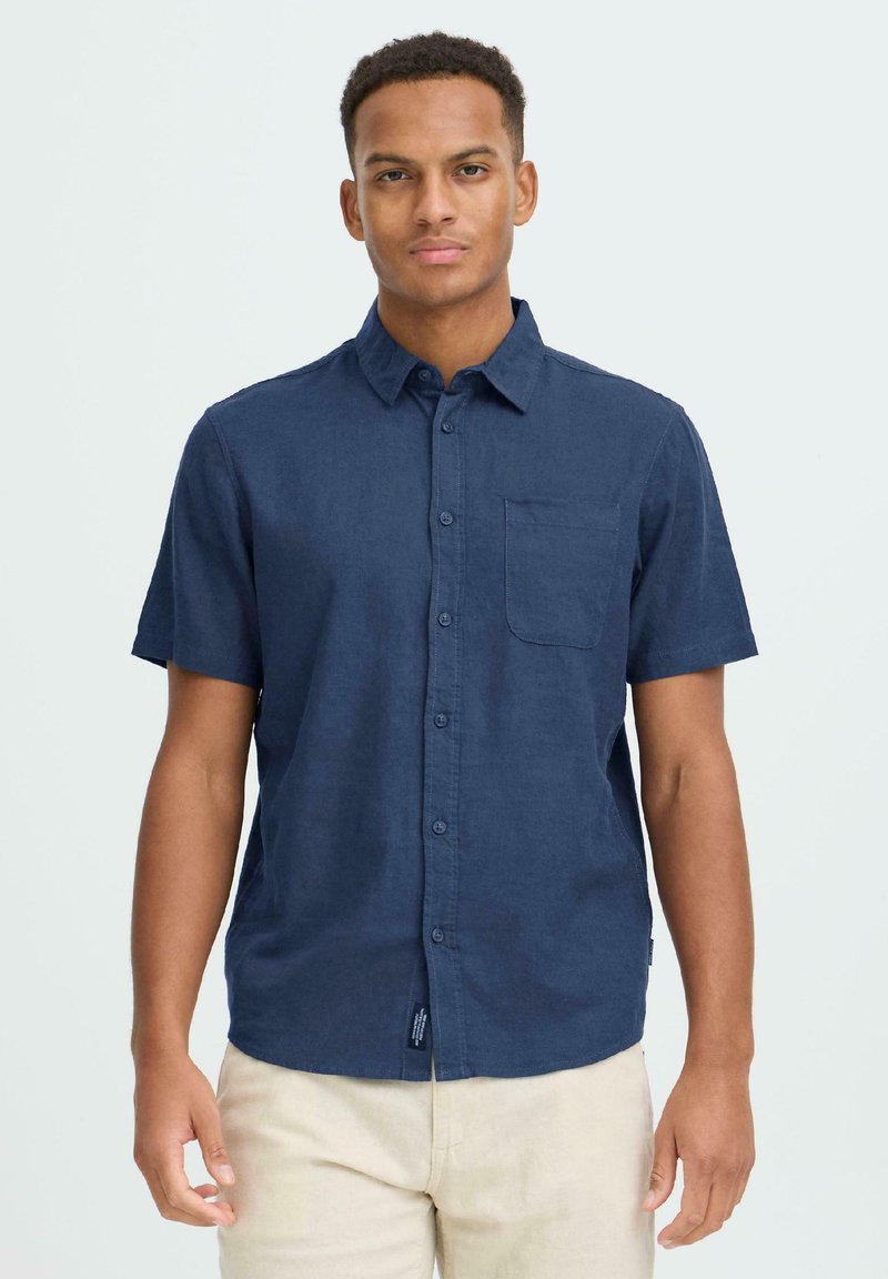 Πουκάμισο με κοντά μανίκια και κουμπιά, κατασκευασμένο από βαμβάκι σε ναυτικό μπλε χρώμα. Διαθέτει τσέπη στο αριστερό στήθος και ευθεία γραμμή στο τελείωμα. Λεία υφή, άνετη γραμμή.