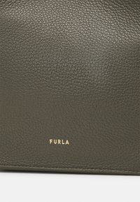Dark green leather handbag with a textured surface, featuring a gold "FURLA" logo at the bottom. Simple, rectangular shape.
