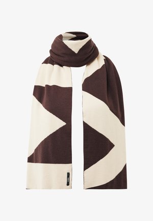 Brązowy i beżowy szal z wyraźnym geometrycznym wzorem w zygzak, złożony i narzucony, z małą czarną metką marki na dolnej krawędzi.