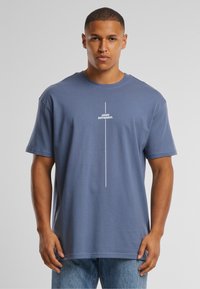 Blue cotton t-shirt with short sleeves, featuring a vertical white text graphic reading "Think Different" on the front. Straight hem.