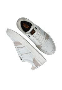 Baskets blanches avec des accents en suède gris, design en cuir texturé, bout rond et fermeture à lacets. Présente un logo bien visible sur la languette.