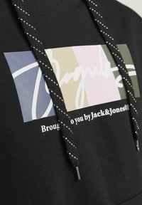 Black sweatshirt with a color-blocked graphic featuring blue, beige, pink, and green sections, and contrasting drawstrings with white stitching.