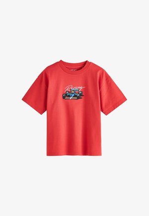 Czerwona koszulka z krótkim rękawem z grafiką niebieskiego samochodu wyścigowego i kierowcy oraz napisem „Racing” nadrukowanym nad samochodem na piersi.