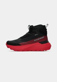 Schwarzer und roter Mid-Top-Wanderschuh mit strukturiertem Obermaterial, Gummi-Sohle, verstärkter Zehenkappe und auffälligem "Mammut"-Logo an der Seite.
