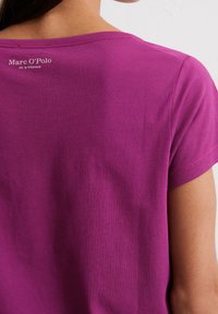 Korte mouwen, ronde hals t-shirt in fel magenta katoen met een soepele textuur, voorzien van een logoprent op de achterkant van de hals.