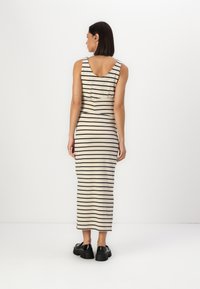 Rochie midi stripe în nuanțe de bej și negru, cu un decolteu în formă de cerc, siluetă ajustată și textură moale. Purtați-o cu încălțăminte chunky de culoare neagră.