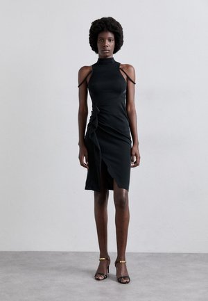 Black bodycon dress with high neck and open shoulders. Features twisted detail at the waist and a thigh-high slit. Smooth texture.