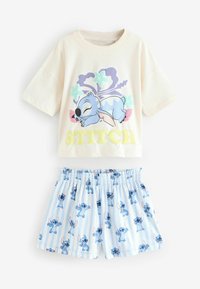 Korte mouwen crèmekleurig t-shirt met een cartoonprint van Stitch en gele tekst, gecombineerd met blauw gestreepte shorts met herhaalde Stitch-ontwerpen.