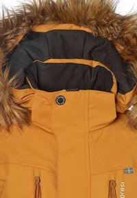 Orange vattentät jacka med en pälsfodrad huva, svart insida, två fickor med dragkedja och en logotyp med blå och gula accenter.