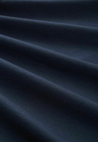 Dunkelblaues Gewebe mit einer glatten Textur, das weiche Falten und ein gleichmäßiges Webmuster zeigt. Ideal für verschiedene Textilanwendungen.