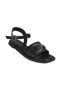 Black leather sandals with a flat sole, featuring an adjustable ankle strap and a metallic accent on the front. Square toe design.