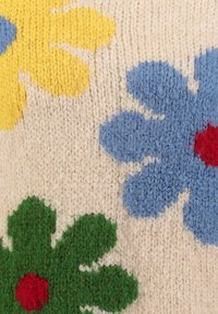 Szyty tekstylia z kolorowymi wzorami kwiatowymi w odcieniach niebieskiego, żółtego, zielonego i czerwonego na kremowym tle; miękka tekstura z widocznymi ściegami.