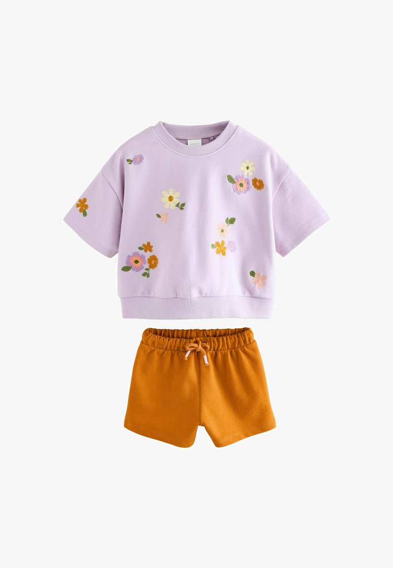 Fliederfarbenes kurzärmliges Top mit bestickten, mehrfarbigen Blumen, kombiniert mit senfgelben Shorts mit elastischem Bund und Kordelzug.