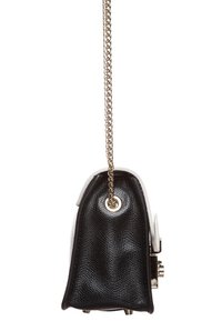 Borsa a mano in pelle nera testurizzata con un dettaglio in pelle bianca, dotata di una tracolla a catena dorata e di un dettaglio hardware rotondo sul lato.