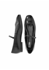 Czarne skórzane baletki z zaokrąglonym czubkiem, paskiem na kostce, niskim obcasem i gładką teksturą. Widok z boku ukazuje delikatny połysk i minimalistyczny design.