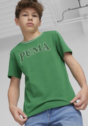 Camiseta de algodón verde con un cuello de acento blanco y un gran logo "PUMA" en un color contrastante. Tiene mangas cortas y un corte relajado.