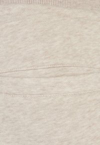 Lichtbeige stof met een zachte textuur, gekenmerkt door een horizontale naaddetail en ribbeltrim aan de bovenkant. Eenvoudig, glad oppervlak.