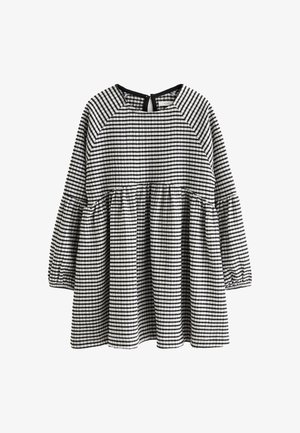 Robe à carreaux noir et blanc avec des manches longues, des poignets smockés, un buste évasé et une ouverture en forme de clé au dos.