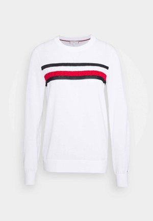Suéter blanco de manga larga con cuello redondo y franjas horizontales negras, blancas y rojas en el pecho.