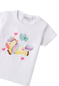 Camiseta blanca de algodón con un diseño colorido de unicornio, adornada con corazones y acentos de strass. Mangas cortas y escote redondo.