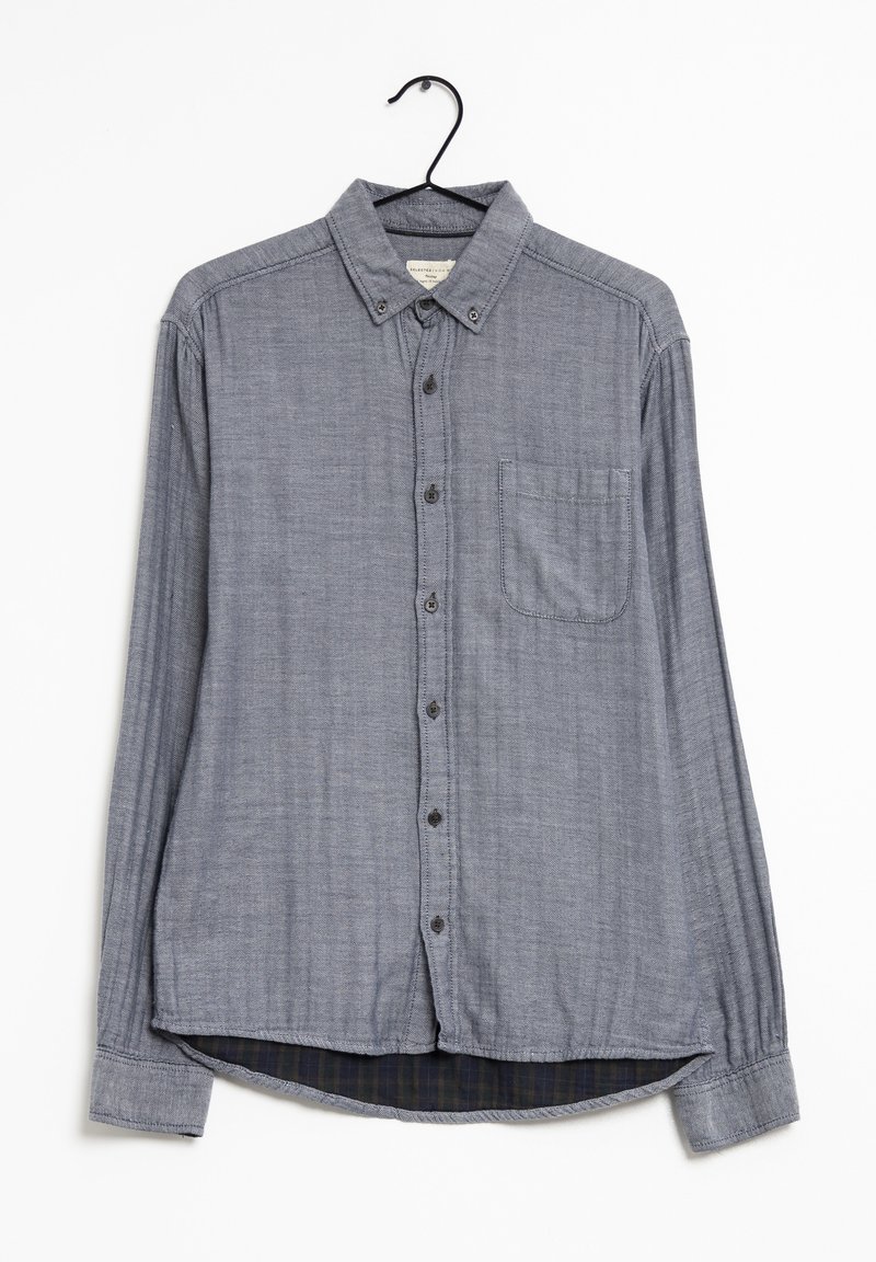 Vaaleansininen pitkähihainen paita, jossa on nappikaulus, etunapit, yksi rintatasku ja ruudullinen vuori helmasssa.