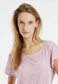 Chemise à manches courtes, rose clair, avec un motif léopard subtil. Tissu doux avec une coupe ample et décontractée et un décolleté large.