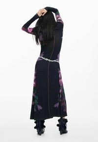 Pikk must kleit lillemustriga, pikkade varrukatega ja hõbedase vööga. Omaduseks on kontrastõmblused ning voogav, tekstureeritud kangamuster.