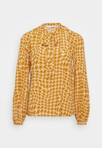 Blusa a maniche lunghe in giallo senape con motivo a scacchi in crema, dettaglio sottile al collo con fiocco e maniche con polsini elasticizzati.