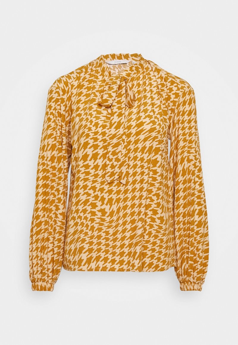 Blusa a maniche lunghe in giallo senape con motivo a scacchi in crema, dettaglio sottile al collo con fiocco e maniche con polsini elasticizzati.