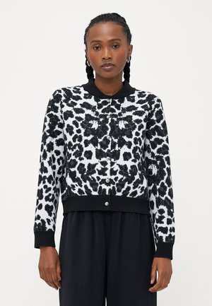 Knitted black and white leopard print cardigan with a black ribbed collar and cuffs, featuring silver buttons along the front.