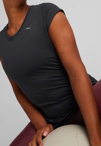 Mörkgrå kortärmad sporttopp med en figurnära design, som har en liten silverlogotyp på vänster bröst och en mjuk, elastisk tyg.