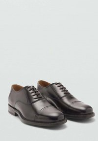 Chaussures habillées en cuir noir avec une finition lisse, bout rond et lacets. Présentent un bout cap et un petit talon empilé.