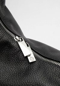 Borsa a mano in pelle nera con superficie texturizzata, cerniera in hardware argentato e un logo prominente sul tirazip.