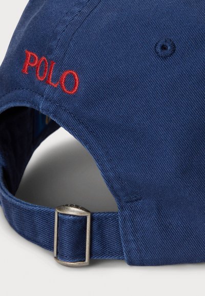 Gorra de béisbol de algodón azul marino con bordado rojo "POLO" y correa ajustable de metal en la parte trasera, con una superficie de tela texturizada.