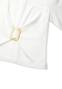 Weißes Oberteil aus Stoff mit einer verdrehten Design-Front, die mit einer rechteckigen goldenen Schnalle gesichert ist. Kurze Ärmel und eine lockere Passform.