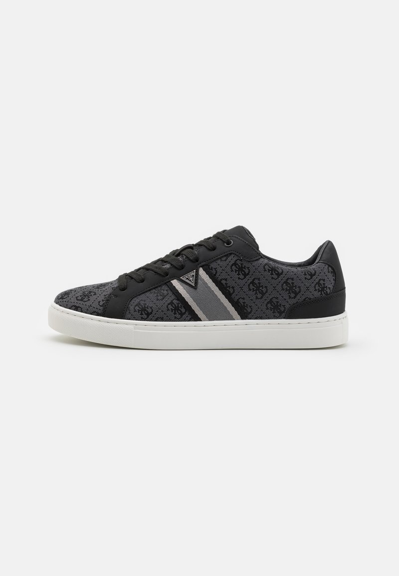 Fekete és szürke sneaker, texturált felsőrésszel, dombornyomott mintával, lapos fűzőkkel és kontrasztos szürke csíkokkal, fehér talpra helyezve.