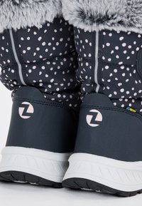 Winterstiefel in Marineblau mit rosa Pünktchen, ausgestattet mit einem Kunstfellbesatz und einer gepolsterten Sohle. Graue Akzente und ein Logo auf der Rückseite sorgen für Details.