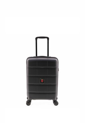 Maleta rígida negra con cuatro ruedas giratorias y un asa telescópica extendida, colocada en posición vertical sobre un fondo blanco.