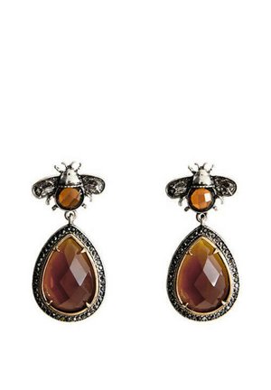 Boucles d'oreilles argentées en forme d'abeille avec petites pierres d'ambre rondes et grands pendentifs en ambre taillés en forme de goutte, encadrés par des accents noirs.