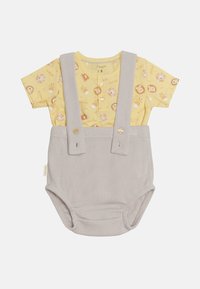 Camisa amarilla de manga corta con estampado de animales, combinada con un overol de canalé gris claro con tirantes y botones.