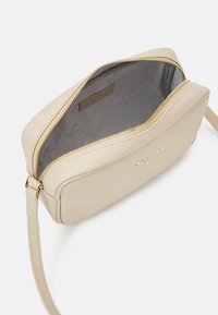 Borsa a tracolla in pelle beige con chiusura a zip. Presenta una superficie liscia e una singola tracolla regolabile. Interno foderato in tessuto grigio.