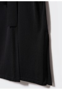 Sort let cardigan med en glat tekstur, der har en omslagsdesign, sidelommer og et bælte, der bindes. Kanten har en lille slids.