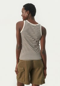 Gestreifter Tanktop in Braun und Creme mit gerippter Struktur, kombiniert mit olivgrünen Cargo-Shorts mit seitlichen Taschen.
