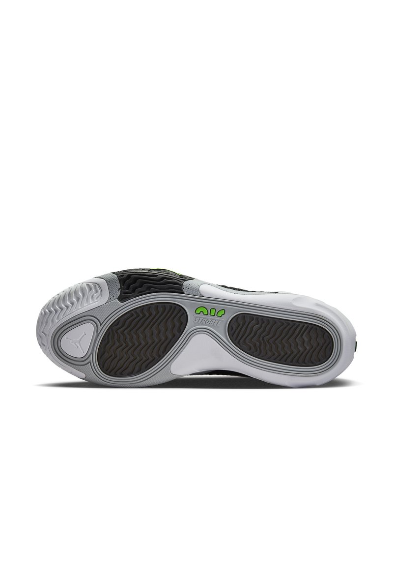 Suela de una zapatilla negra, blanca y gris con agarre texturizado, marca "AIR STROBEL" en verde y un pequeño logo de Jumpman cerca del talón.