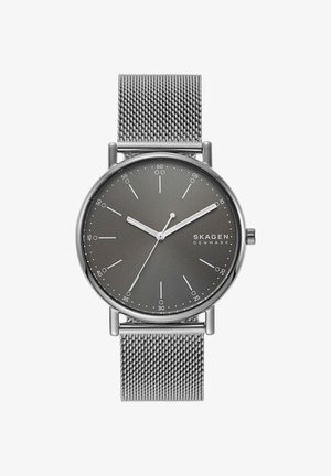 Sølv Skagen armbåndsur med grå minimalistisk urskive, mesh-rem og time-, minut- og sekundviser, der viser 10:10:35.