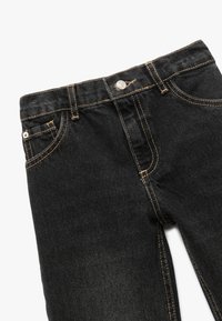 Jeans in denim nero con un design classico, caratterizzati da cuciture gialle, chiusura frontale con bottone e il tradizionale stile a cinque tasche.